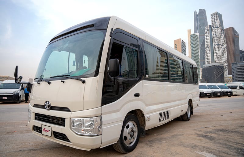 A Toyota Coaster from the Flow Mobility fleet in front of Riyadh's towers